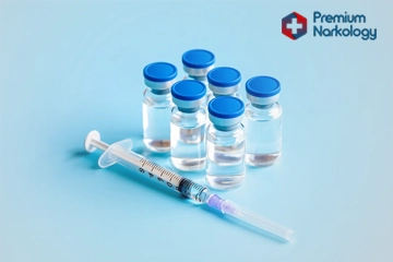 Шприц с медикаментом и пузырьки с лекарством